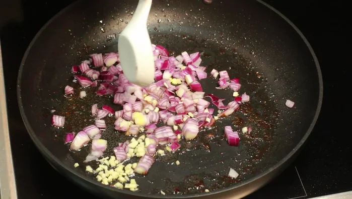 Tomatenmark hinzufügen und alles verrühren, 2 Minuten andünsten.