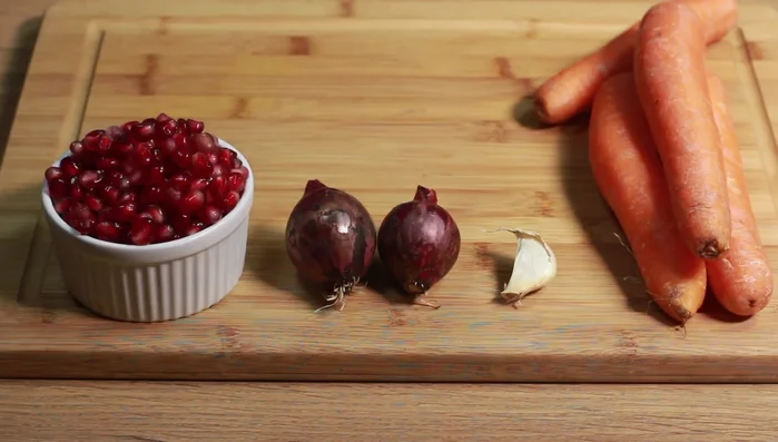 Granatapfelkerne entfernen (siehe Video in der Infobox). Zwiebeln und Knoblauch schälen und hacken.