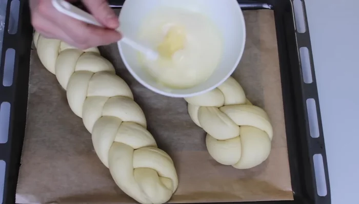 Milch, Ei und etwas Zucker verrühren und den Hefezopf damit bestreichen.