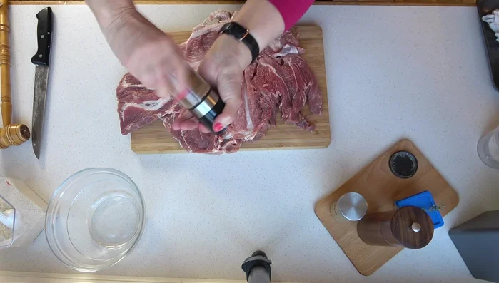 Braten flach klopfen und mit Salz, Rosmarin, Thymian, Pfeffer und Gewürzmischung würzen.