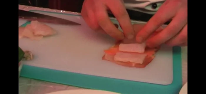 Rohschinken darauflegen, fest zurollen, aufrollen und halbieren.