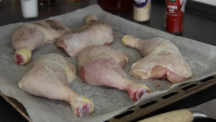 Hähnchenkeulen mit Salz, Pfeffer und Paprikapulver würzen.