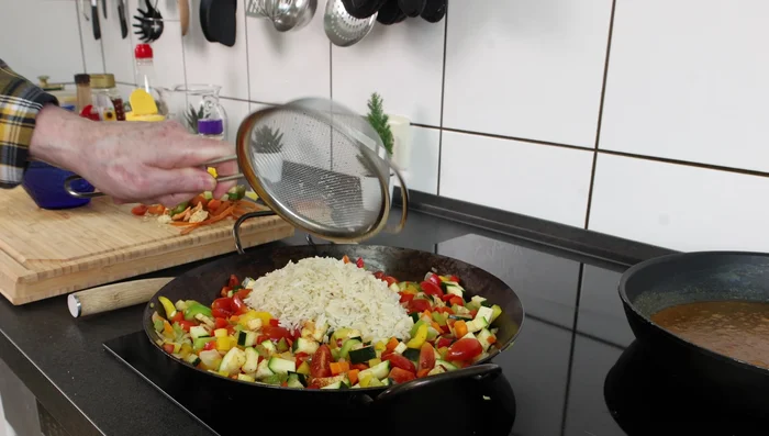 Reis waschen und mit Brühe, Wasser und Knoblauchpulver kochen.