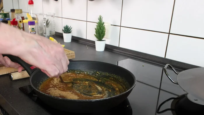 Nach ca. 30 Minuten Backzeit braunen Zucker in die Glasur einrühren und die Hähnchenkeulen damit bestreichen. Backofen auf Oberhitze 200°C erhöhen.