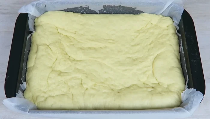 Teig nochmals 20 Minuten abgedeckt gehen lassen. Mit dem Finger Mulden in den Teig drücken.