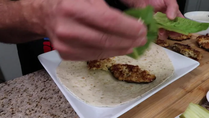 Wrap zusammenstellen: Tortilla mit Salat, Tomaten, Zwiebeln, Essiggurken, Salami, Provolone Käse belegen. (399.28)