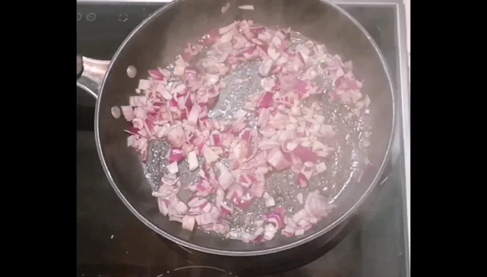 Pilze klein schneiden, in Butter mit roten Zwiebeln und Schinkenwürfeln anbraten.