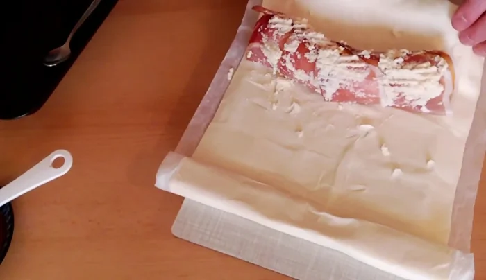 Den Blätterteig vorsichtig einrollen und die Enden gut verschließen (z.B. mit einer Gabel).