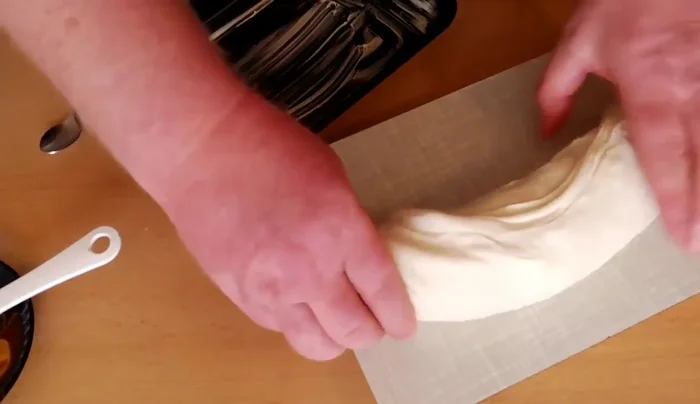 Die Rolle auf ein mit Backpapier ausgelegtes Backblech legen.