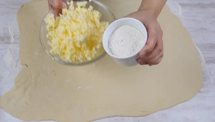 Gefrorene Butter auf einer Hälfte des Teigs reiben, die andere Hälfte darüberklappen und die Ränder gut verschließen.