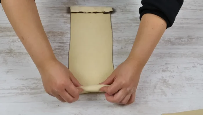 Croissants auf ein mit Backpapier ausgelegtes Backblech legen, abdecken und 30 Minuten ruhen lassen.