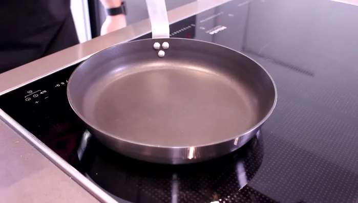 Olivenöl in einer Pfanne erhitzen und die Zwiebelwürfel glasig andünsten (240.65).