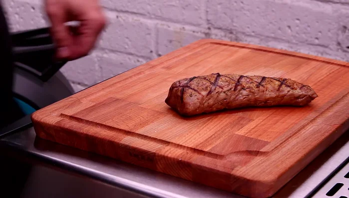 Lammlachs ruhen lassen, anschneiden und mit Orangensauce servieren (458.409).