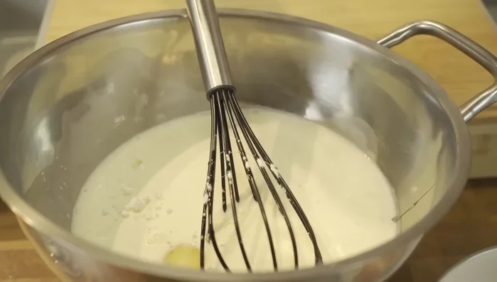 Eier und Eigelb unter die Milchmischung heben. Vorsichtig verrühren, nicht schaumig schlagen!