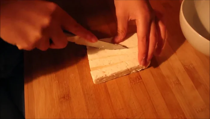 Die Soße über den Salat geben.