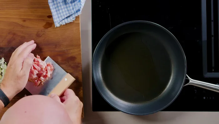 Speck in Öl anbraten, Zwiebeln hinzufügen und glasig anschwitzen. Alles in eine Schüssel geben.