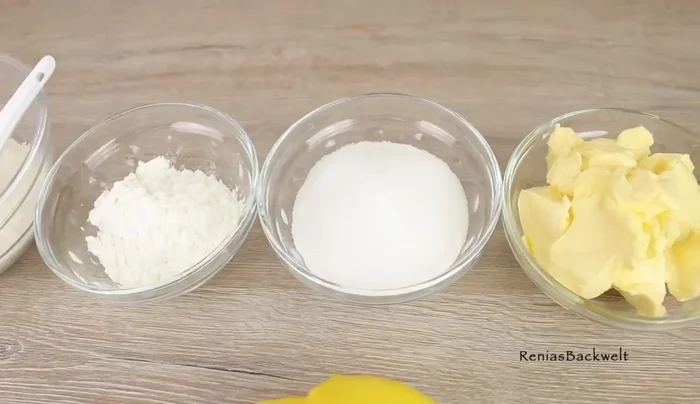 Für den Boden: Mehl, Backpulver, Speisestärke, Zucker, Margarine, Eier und die abgeriebene Schale einer Bio-Zitrone vermischen.