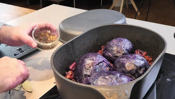 Mit restlichem Rotkohlsaft, Gewürzen (Lorbeerblätter, Kümmel, Wacholderbeeren, Pfeffer), dünn geschnittenem Speck und dem Blanchierwasser auffüllen. (554.22)