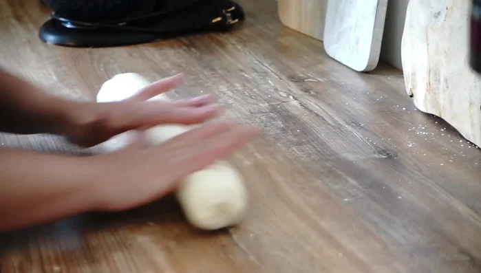 Teig in 12 Portionen teilen (ca. 80-90g). Jeden Teigfladen dünn ausrollen.