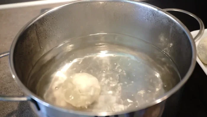 Knödel in Salzwasser ca. 20-25 Minuten ziehen lassen (nicht kochen!). Die Knödel schwimmen obenauf, wenn sie fertig sind.