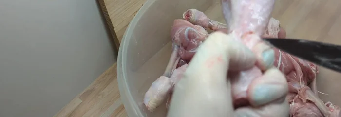 Hähnchenkeulen entlang des Knochens durchschneiden und die Haut an zwei Stellen einschneiden, um sie leichter abziehen zu können. (22.859)