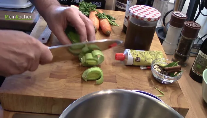 Suppengrün in Stücke schneiden und hinzufügen. Zimt, Nelken, Piment, Fenchelsamen, Kümmel und Salz hinzufügen.