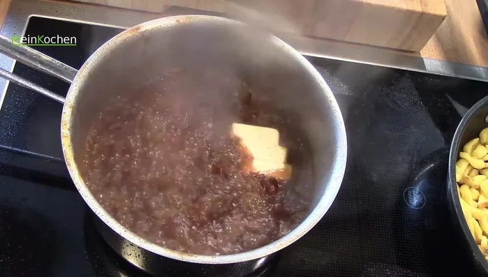 Kalte Butter in die Sauce einrühren, um sie zu binden.