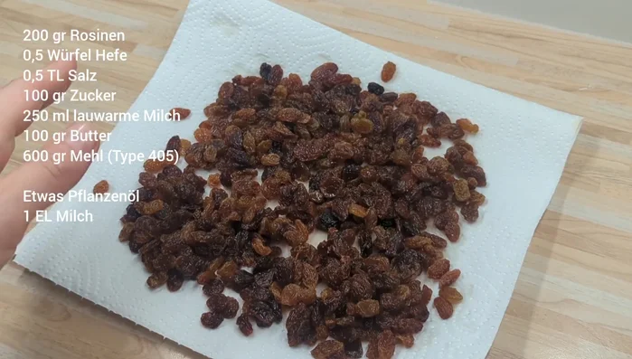 Rosinen unter fließendem Wasser spülen und auf einem Küchentuch trocknen lassen.