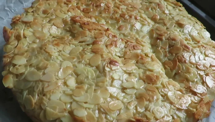 Den abgekühlten Kuchen halbieren, mit Pudding füllen und die Mandelkruste wieder auflegen.