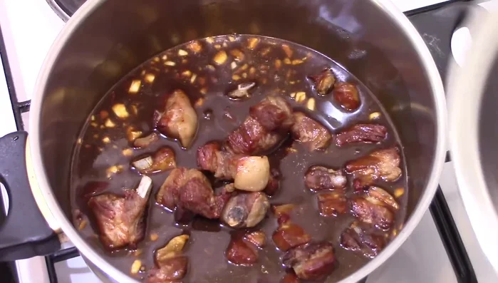 Pooris in die Sauce geben und bei sehr geringer Hitze mit Deckel eine Stunde köcheln lassen. Während des Kochens umrühren.