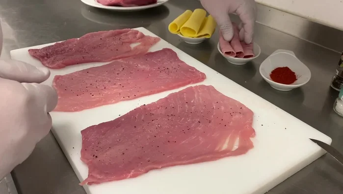 Kochschinken auf die Schnitzel legen.