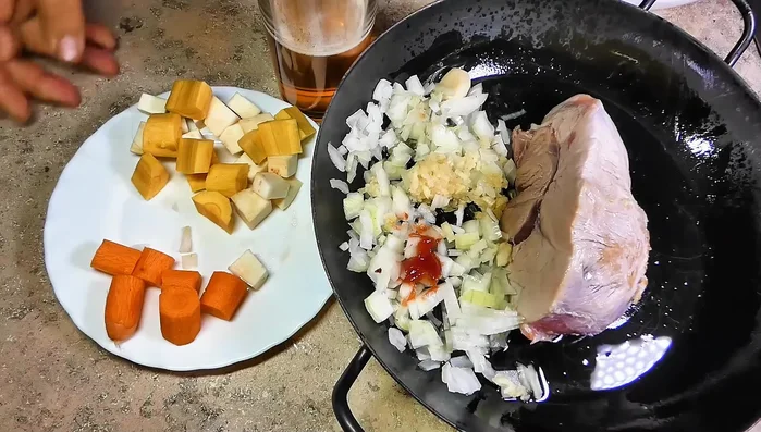 Tomatenmark, Zwiebeln, Karotten und Sellerie hinzufügen und kurz mitbraten.