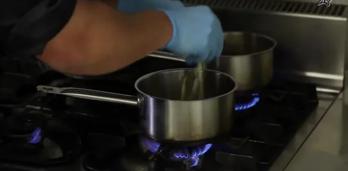 Für die Calvados-Sauce: Butter in einer Pfanne schmelzen, Apfelwürfel dazugeben und glasieren. Mit Calvados flambieren und reduzieren.