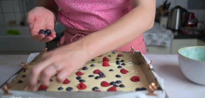 Heidelbeeren und Himbeeren (oder andere Früchte) auf dem Teig verteilen.