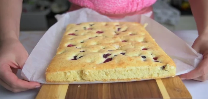 Kuchen aus dem Backblech lösen und mit Puderzucker bestäuben.