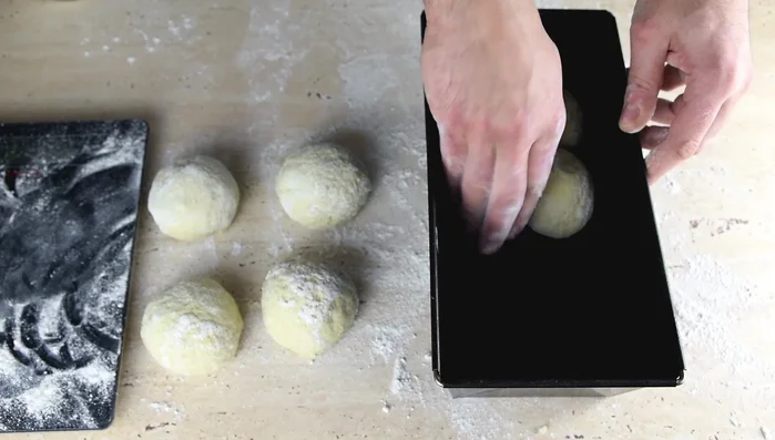 Backform fetten und die Teigstücke hineinlegen. Etwa 1 Stunde bis 1 Stunde 20 Minuten gehen lassen (ohne Hefe 2-6 Stunden, im Kühlschrank über Nacht möglich).