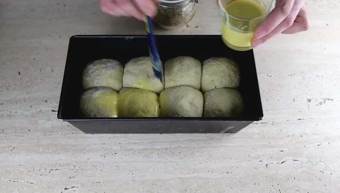 Senfkruste zubereiten: 1/2 Teelöffel Senf mit etwas Wasser vermischen und den Teig damit bestreichen. Mit Sonnenblumenkernen bestreuen.