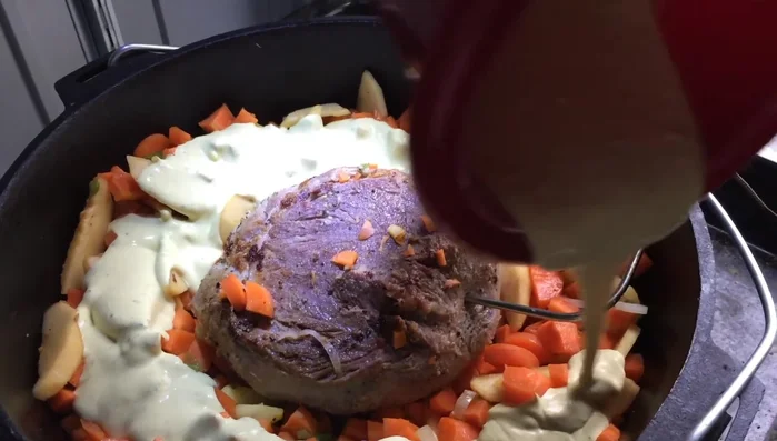 Gemüse mit der Sahne-Würzmischung übergießen, Topf schließen.