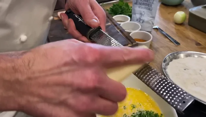 Petersilie hacken und mit geriebenem Parmesan vermischen (76.31, 79.409, 82.38). Gewürze auf die Schnitzel geben (89.119).