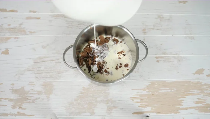 Für die Schokosauce: Gehackte Bitterschokolade und Vollmilchschokolade über niedriger Flamme schmelzen (nicht kochen).