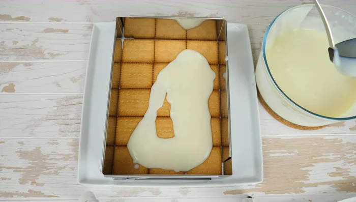 Eine Schicht heißen Pudding auf die Kekse geben. Diesen Vorgang wiederholen, bis vier Schichten Kekse und Pudding übereinander liegen.