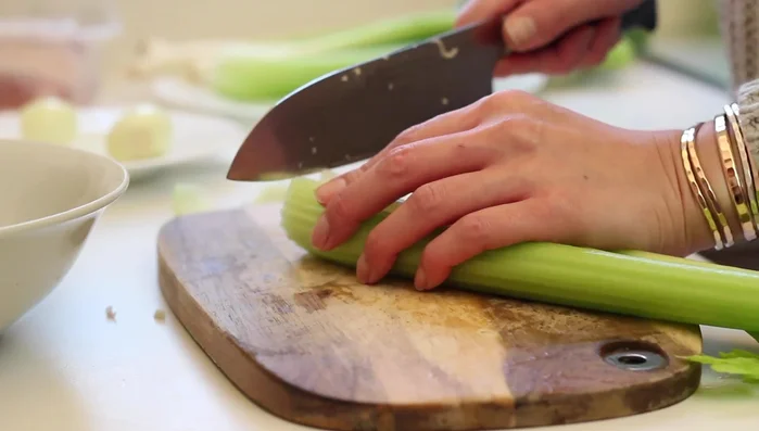 Zwiebeln, Sellerie und Frühlingszwiebeln in Würfel schneiden.