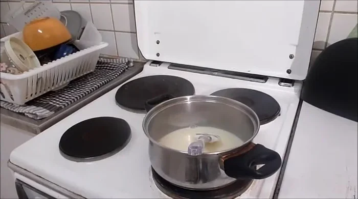 Schokolade in die kochende Milch-Creme-Mischung geben und schmelzen lassen. Etwas abkühlen lassen.