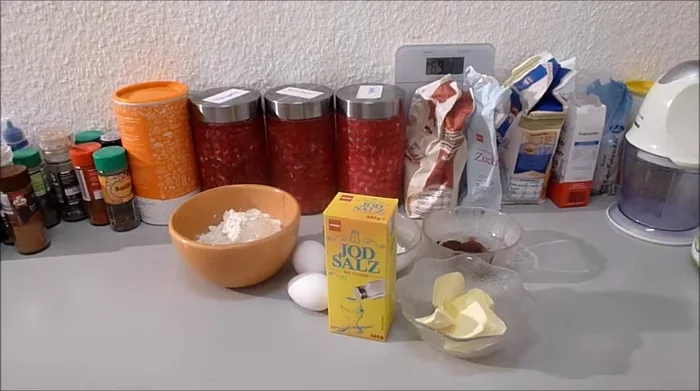 Zutaten für den Teig vermengen: Mehl, Backkakao, Puderzucker, Salz, Eier und Butter in einer Schüssel zu einem glatten Teig verrühren.