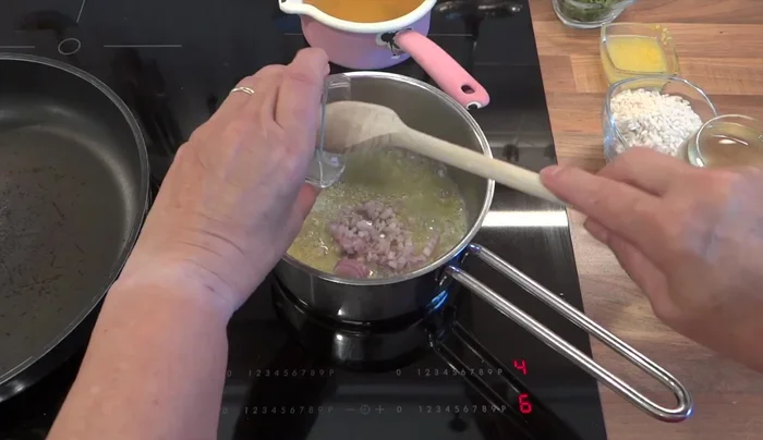 Zitronenreis zubereiten: Butter schmelzen, Schalotte darin andünsten, Risottoreis hinzufügen und leicht anbraten. Mit Weißwein ablöschen.