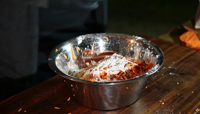 Geriebene Süßkartoffel mit Ei, Mehl, Salz und Pfeffer vermengen.