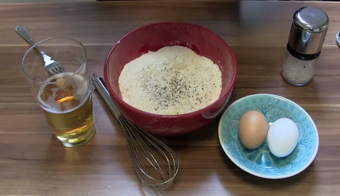 Pfeffer und Salz hinzufügen. Eier in die Mulde geben.