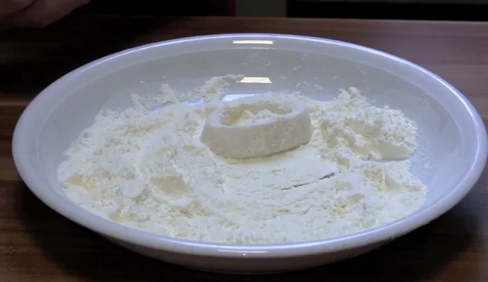 Tintenfischringe im Mehl wenden.