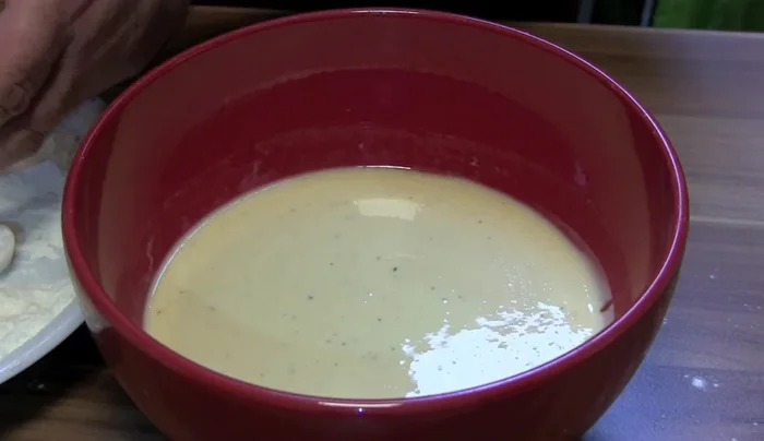 Tintenfischringe im Bierteig wenden, überschüssigen Teig abtropfen lassen.