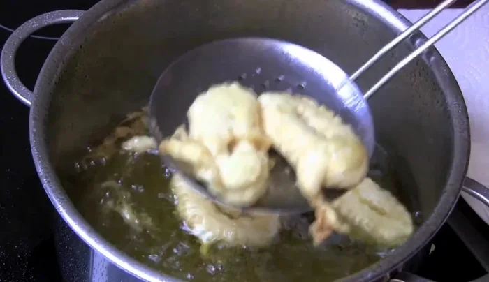 Frittierte Ringe auf Küchenpapier legen, um überschüssiges Öl zu entfernen.